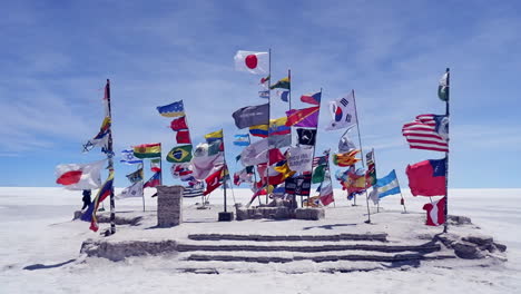 plaza of flags fluttering in breeze on vast uyuni salt flat, bolivia