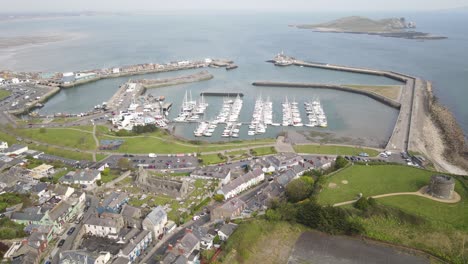 aerial view of howth village near howth pier with boats and ireland's eye at daytime in dublin, ireland