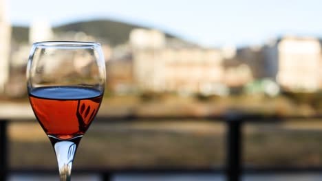 red wine swirling in a glass outdoors