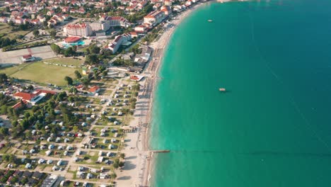 flyover shot of the coastline of a city on krk island, croatia