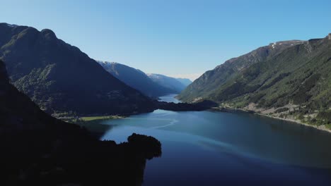 Tiro-De-Dron-Ascendente-De-Un-Hermoso-Lago-En-Un-Valle-De-Colinas-Boscosas