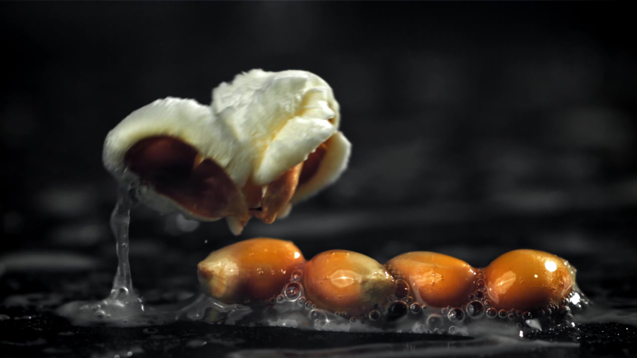 Primo piano di un chicco di mais che scoppia in popcorn al rallentatore
