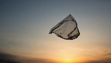 plastic bag blowing in the wind against a sunset sky