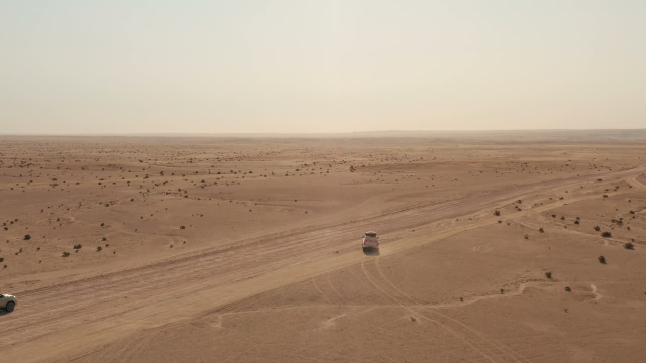 다른 4x4 드라이브가 지나가는 동안 비포장 도로에서 빠져나오는 4x4 자동차 주변을 비행하는 드론