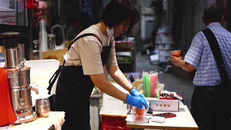 vendor serves juice to customers at market