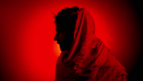 dramatic, stylistic, jesus christ in red glowing light for christianity, easter visual, bible scene or temptation, prayer, worship visual.