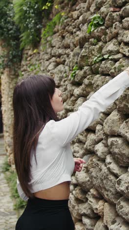 woman putting a piece of paper with a secret desire inside the old wall