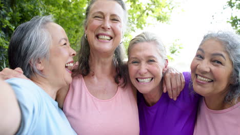 Senior-biracial-woman-and-Caucasian-woman-enjoy-a-sunny-day-by-the-pool