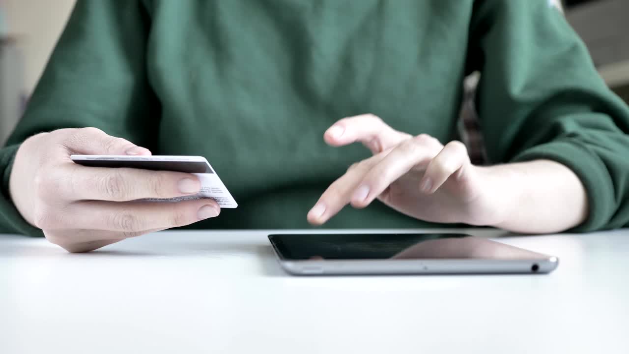 mano femenina sosteniendo una tarjeta de crédito y enviando mensajes de texto en su tableta banca en línea, concepto de compras 60 fps
