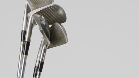 close up of golf clubs on white background, copy space, slow motion