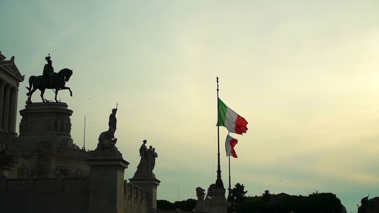 Due bandiere italiane su aste fuori da un antico edificio romano, slow motion