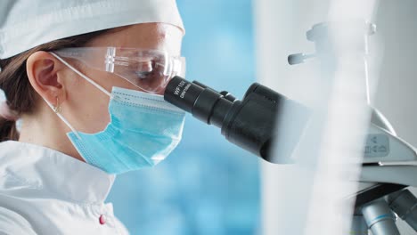 científico mirando a través de un microscopio