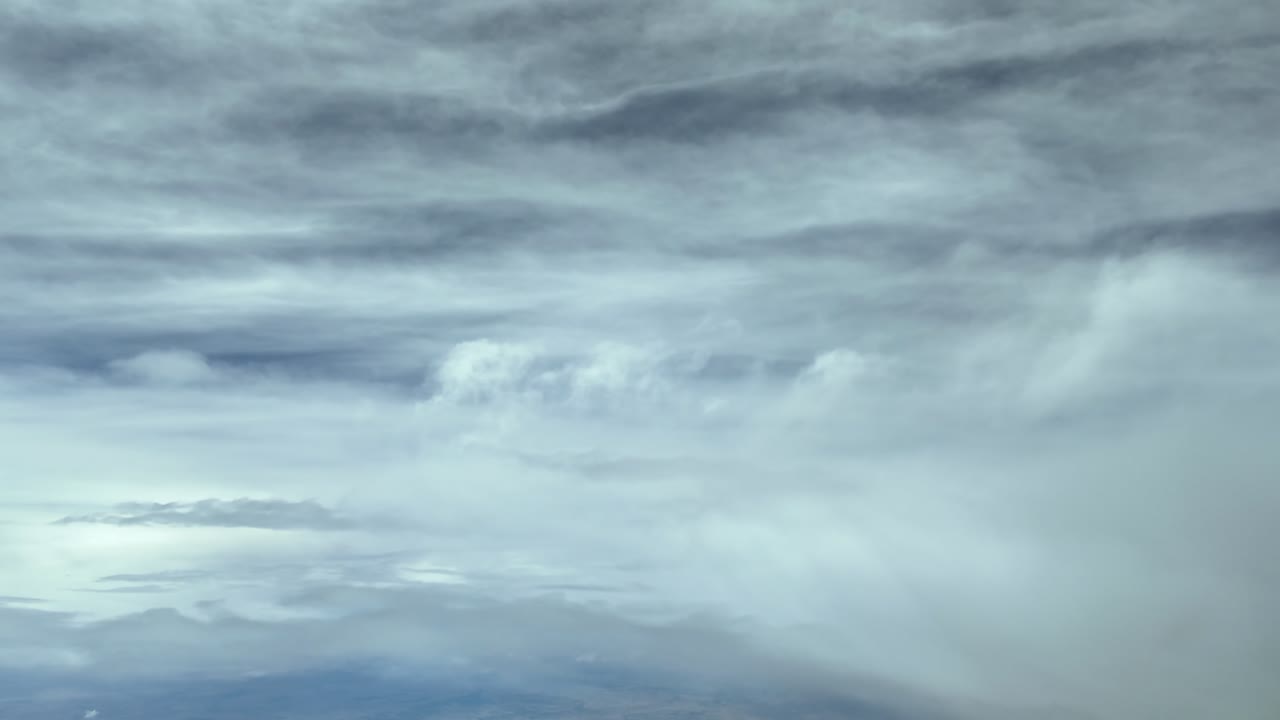 An immersive pilot’s eye view taken from. a jet cockpit flying through layers of ethereal clouds at supersonic speed under a blue sky