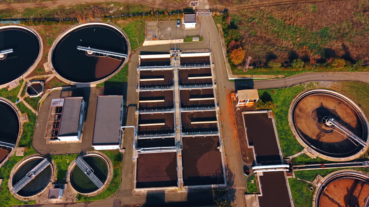 Flight over the territory of modern sewage treatment plant. Flock of birds flies over the circle and rectangular reservoirs with water