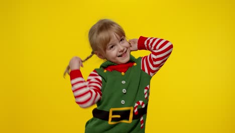 Kid-girl-in-Christmas-elf-Santa-helper-costume-dancing,-fooling-around.-New-Year-holiday-celebration