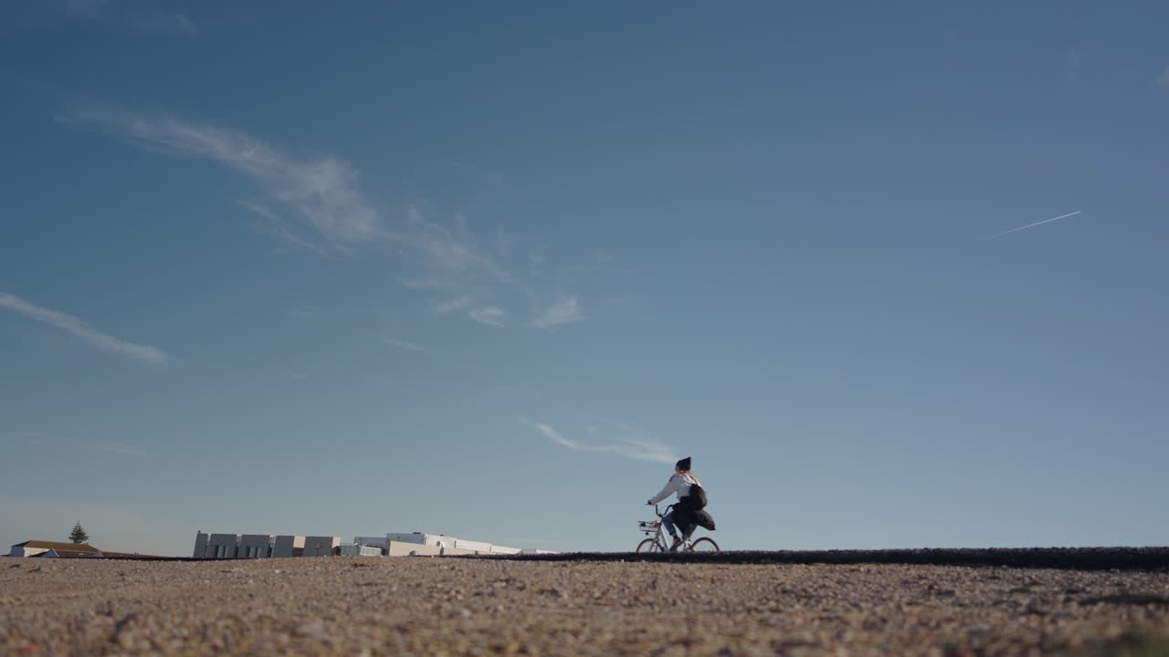 여성 자전거 타기 자전거, 낮은 각도의 뒷모습, 푸른 하늘, 슬로우 모션