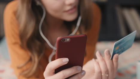 Hermosa-Mujer-Comprando-En-Línea-Con-Tarjeta-De-Crédito-Y-Teléfono-Inteligente-En-Casa-En-Un-Moderno-Apartamento-Tipo-Loft