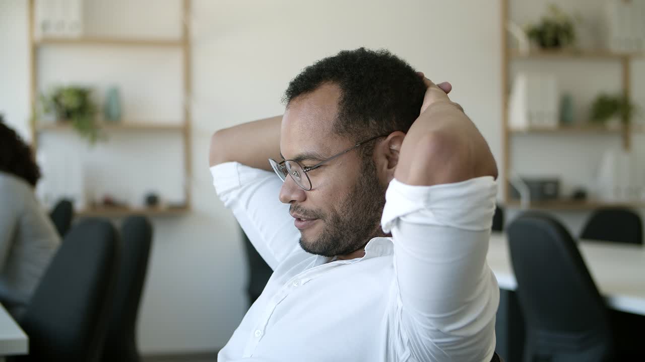 Exhausted African American worker reclining in chair