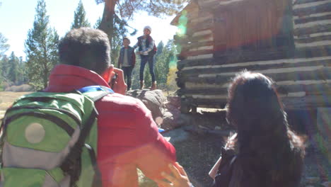 Papá-Tomando-Fotos-De-La-Familia-Junto-A-Una-Cabaña-De-Madera-En-Un-Bosque,-Filmado-En-R3d