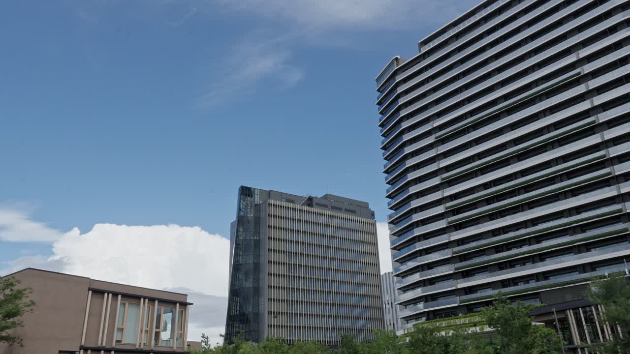 A low-angle view of two modern skyscrapers against a bright sky, ideal for urban and architecture themes