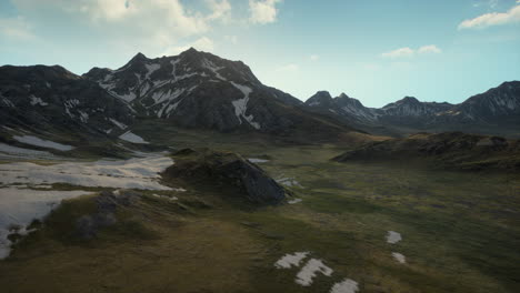 mountain range with snow-capped peaks and green grass