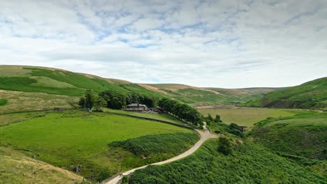 Imágenes-Aéreas-De-Los-Páramos-De-Los-Valles-De-La-Campiña-De-Yorkshire-Y-Moviéndose-Lentamente-Por-Un-Sendero-Hacia-Una-Granja