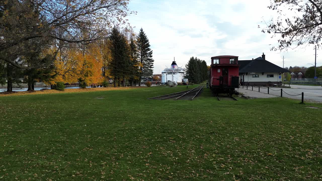 드론이 공원을 지나 큰 배를 지나 온타리오의 작은 호수 마을로 날아갑니다.