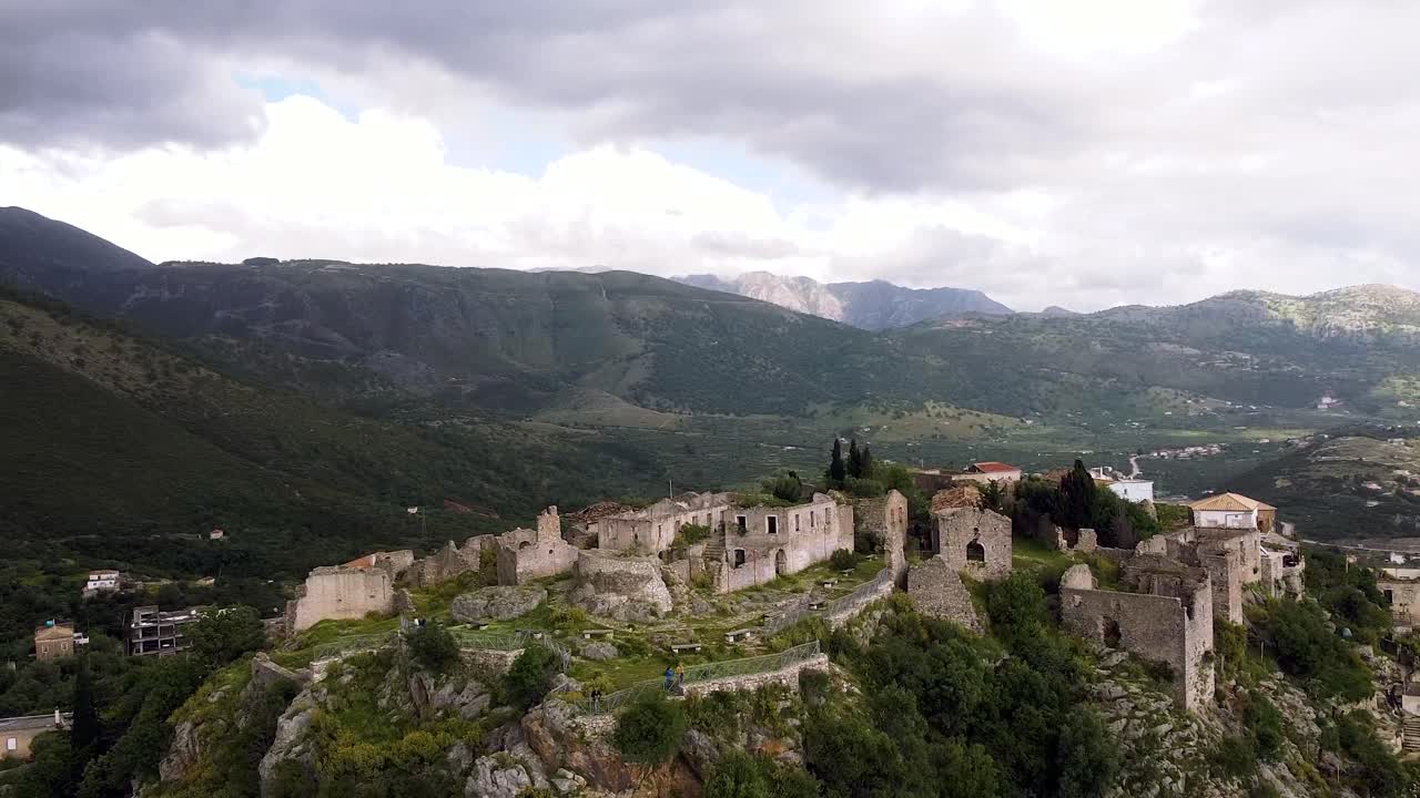 imágenes de drones del castillo de himara en albania, mostrando ruinas antiguas contra un telón de fondo de colinas onduladas y cielos nublados
