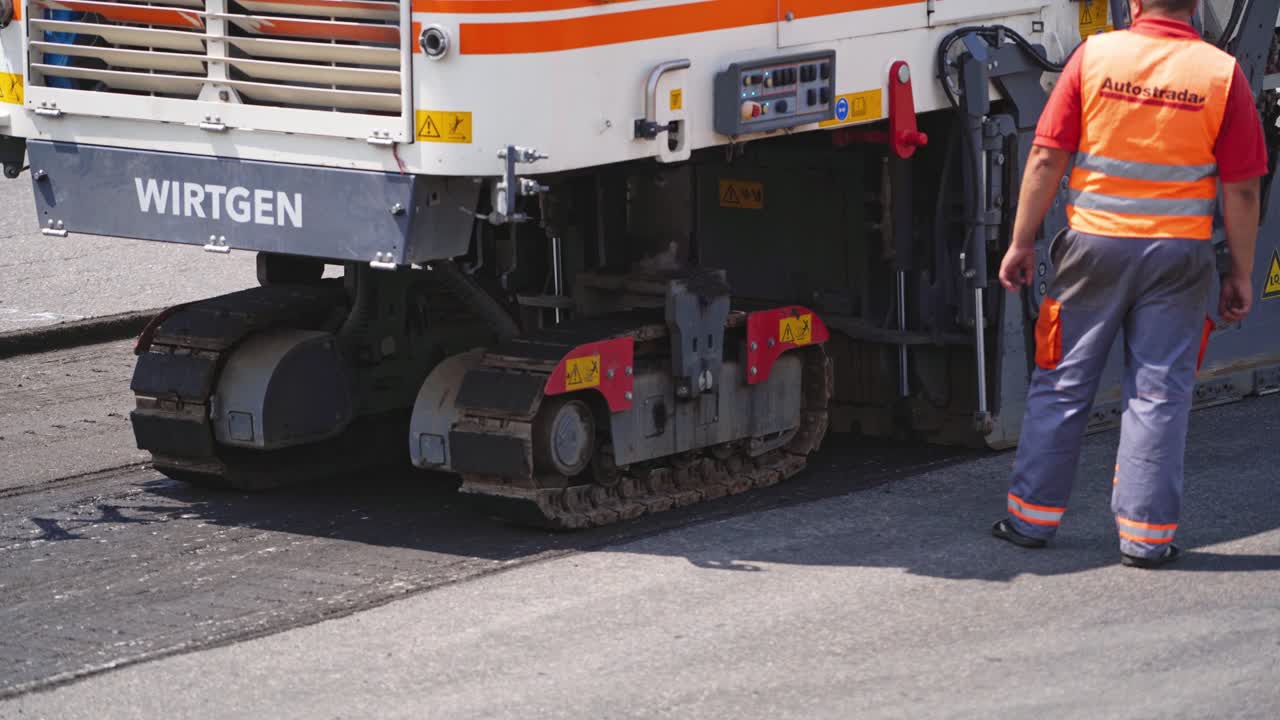 Construction During Asphalting Works. Asphalt paver machine operating during road construction and repairing works