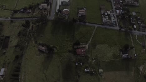 flight over the green field of the boyaca colombia region, it is possible to appreciate the shadow of the trees on the grass, in addition to some vehicles passing on the road