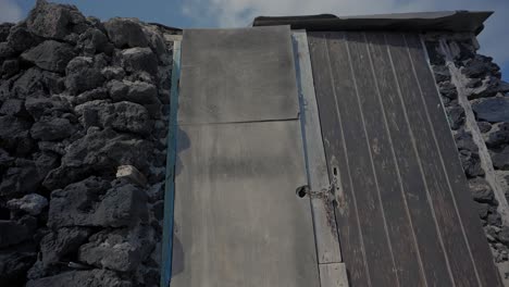 casa construida con rocas volcánicas y puerta cerrada