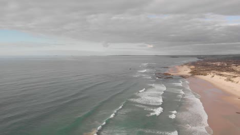 Waves-rolling-onto-pristine-white-sand-beach,-coastal-dunes