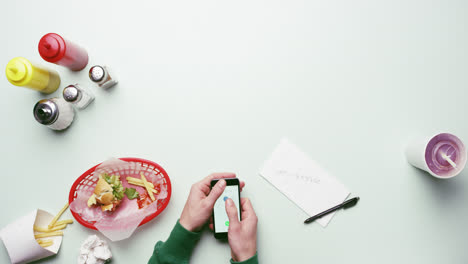 vista superior hombre marcando número usando tecnología de teléfono inteligente con pantalla táctil digital en restaurante de comida rápida americano manos desde arriba - dragón épico rojo