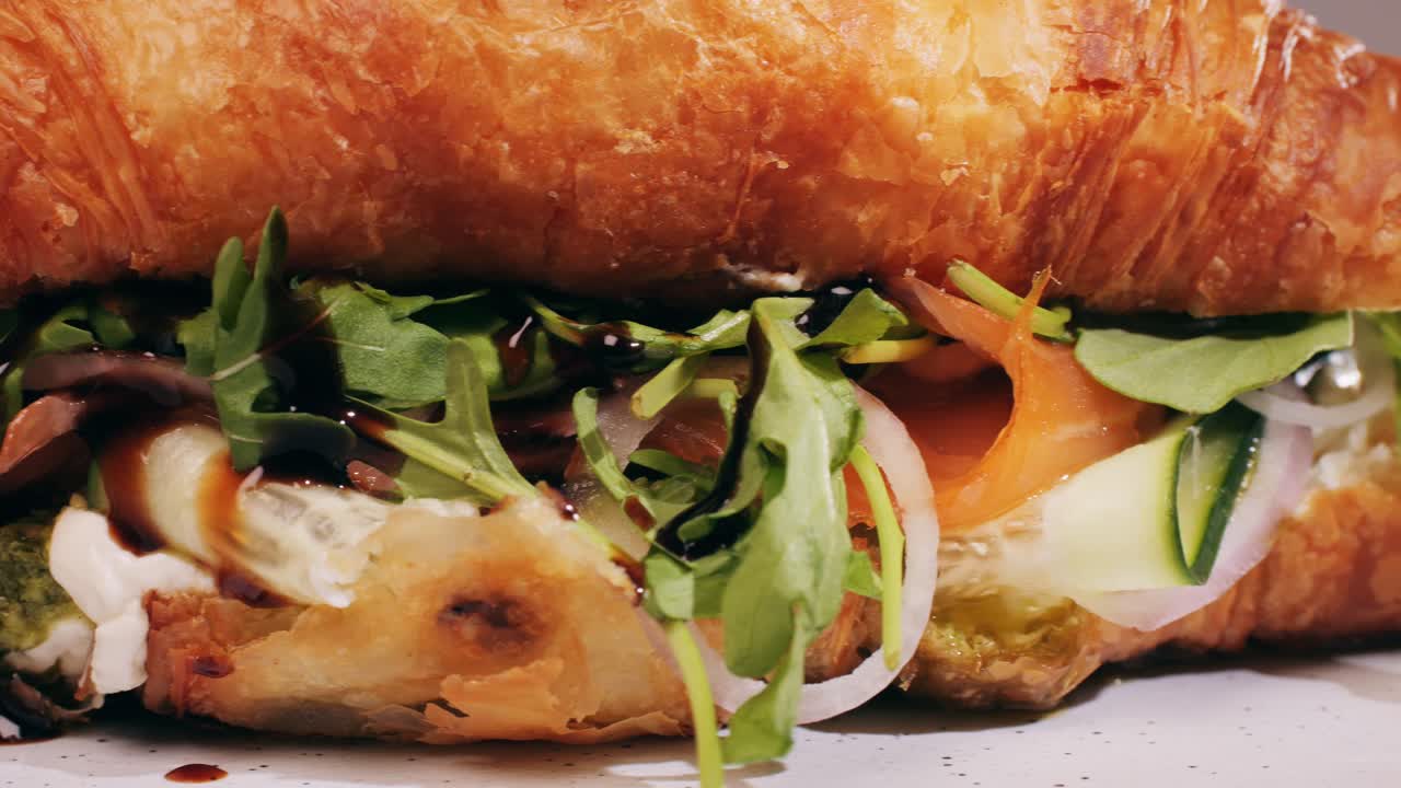 Croissant with jamon ham, Salmon, in Modern Cafe, Top View of Healthy Breakfast in Cafe. English breakfast: fried egg, bacon toast on sandwich.