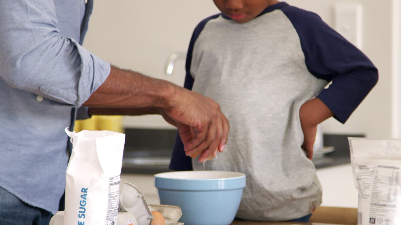 padre e hijo horneando pasteles en la cocina juntos