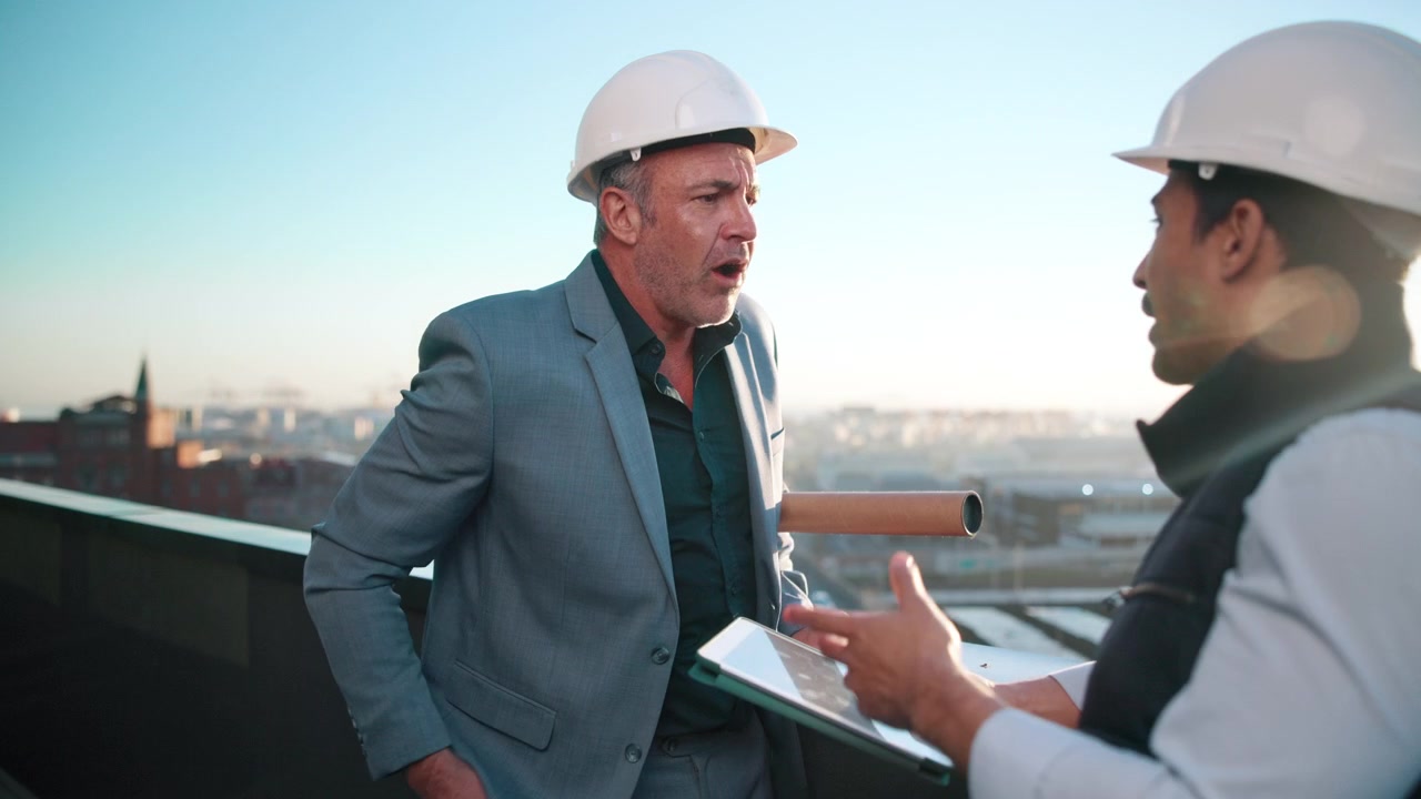 Arquitecto e ingeniero discutiendo un proyecto de construcción en la azotea