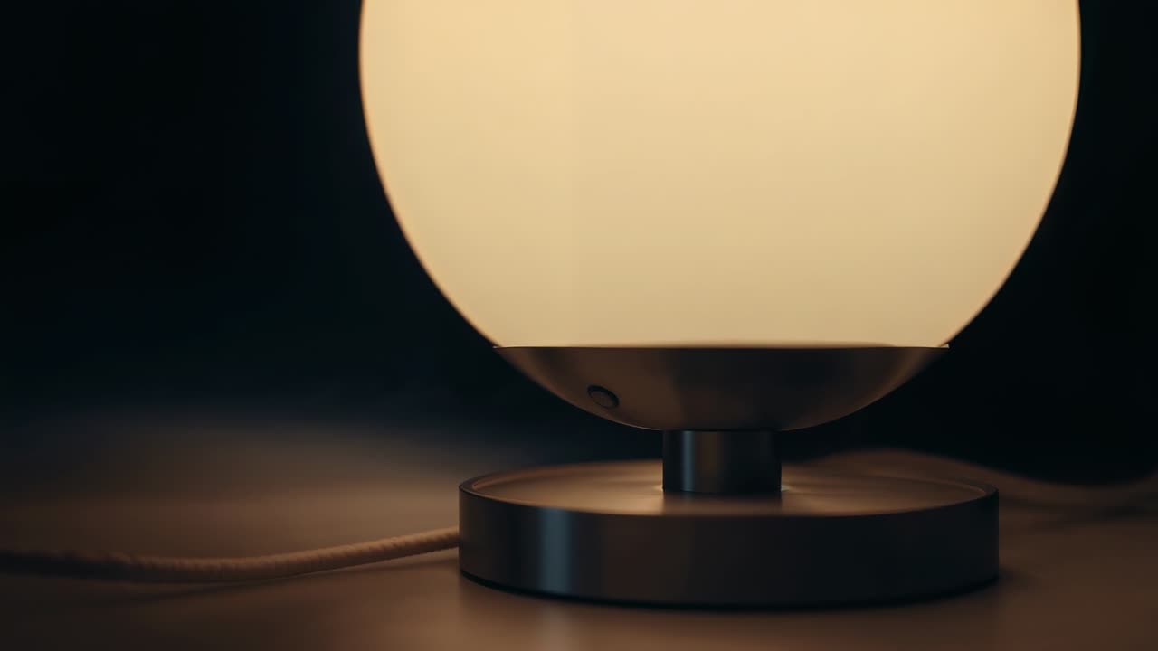 Vertikal video: Kameran dras tillbaka för att avslöja en frostat lampa, metallfot, tygsladd på bordsskiva.