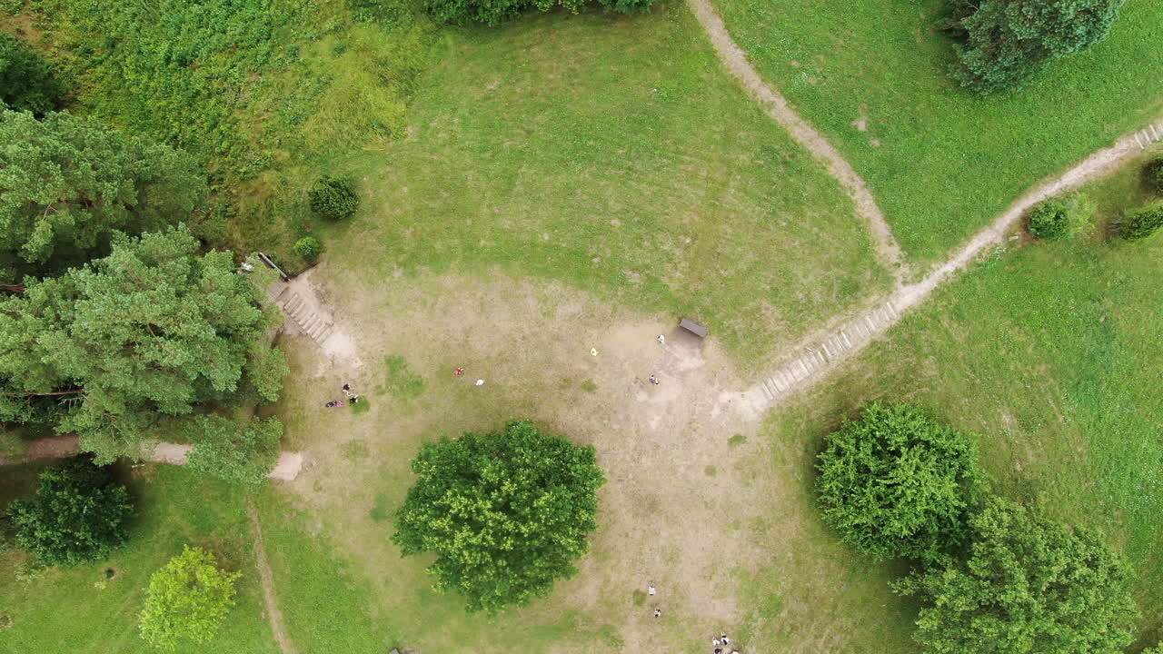 Green and vibrant castle mound with walkways, top down aerial view