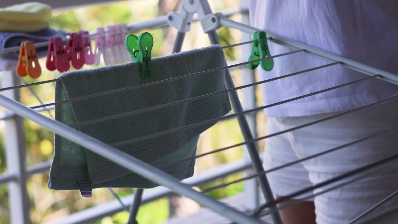 옷줄 에 수건 을 매달고 있는 사람