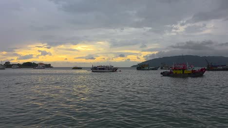 fishing boats on harbor at sunset in kota kinabalu, sabah, malaysia. view from kk waterfront. wide static shot