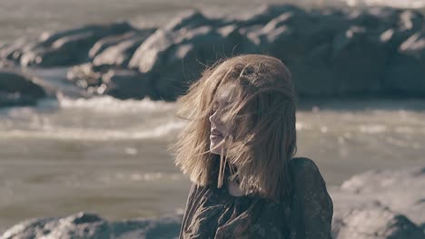 red haired lady in tight clothes poses on rocks slow motion