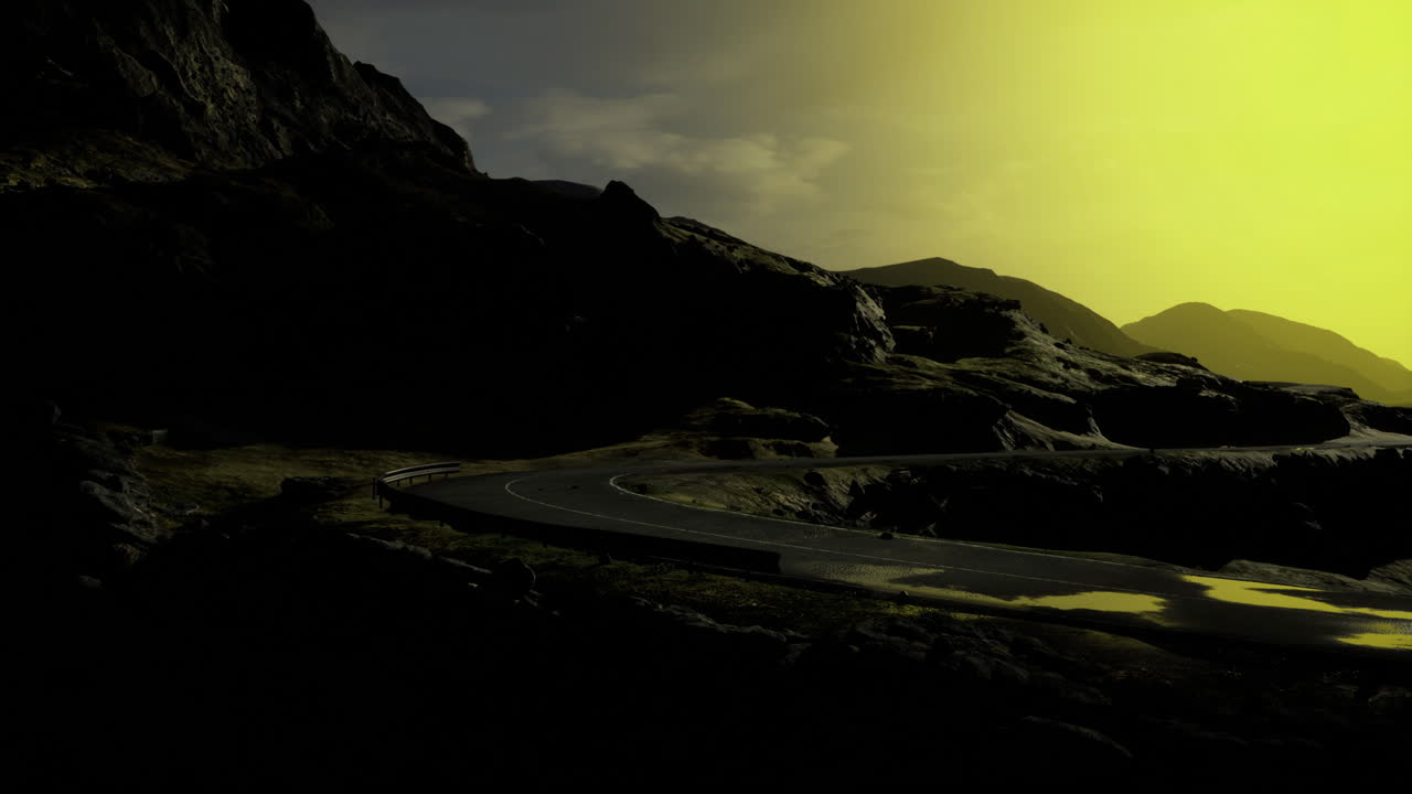 Sunset over winding road in mountainous landscape with dramatic lighting