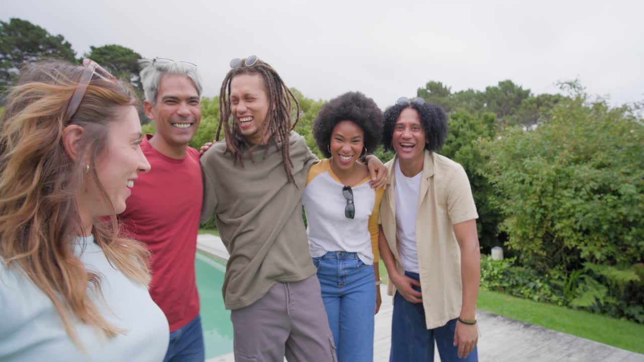 Diverse friends stepping closer as woman holding smartphone gesturing, fitting everyone by pool