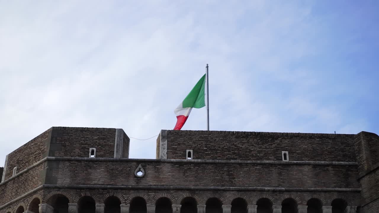 Bandiera italiana che sventola sopra antiche mura di fortezza romana