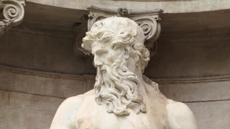 close-up image of the statue of the god neptune in the trevi fountain, rome, italy