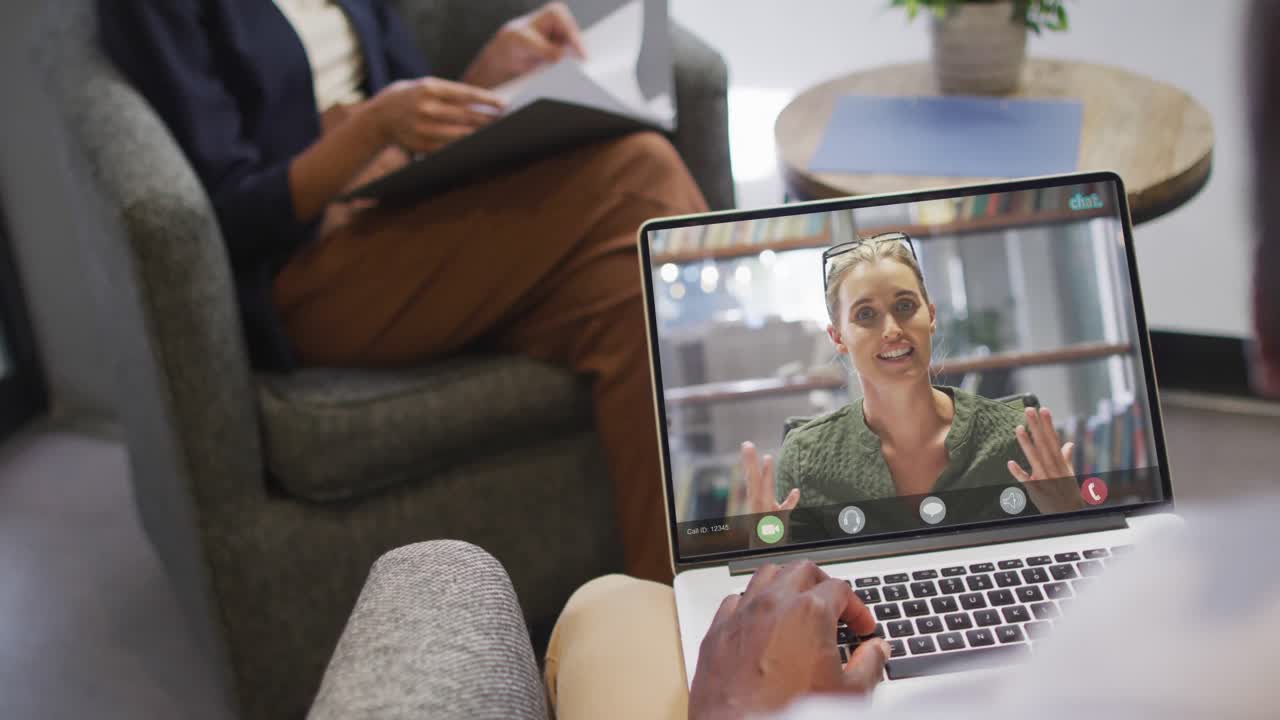 African american businessman using laptop for video call with caucasian business colleague