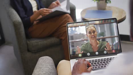 african american businessman using laptop for video call with caucasian business colleague