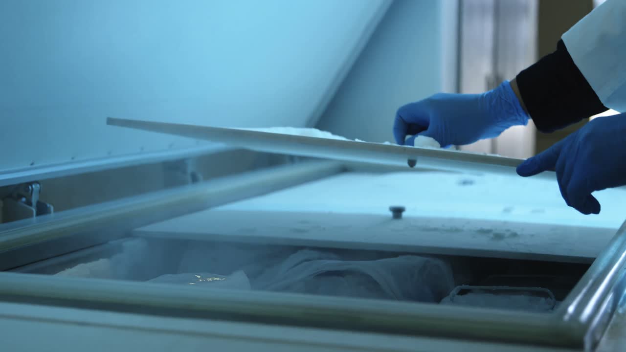científico abriendo la tapa del congelador en el laboratorio 4k