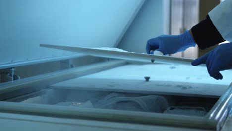científico abriendo la tapa del congelador en el laboratorio 4k