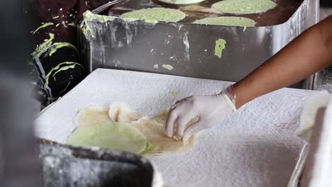 persona que prepara y dobla crepes de algodón de caramelo